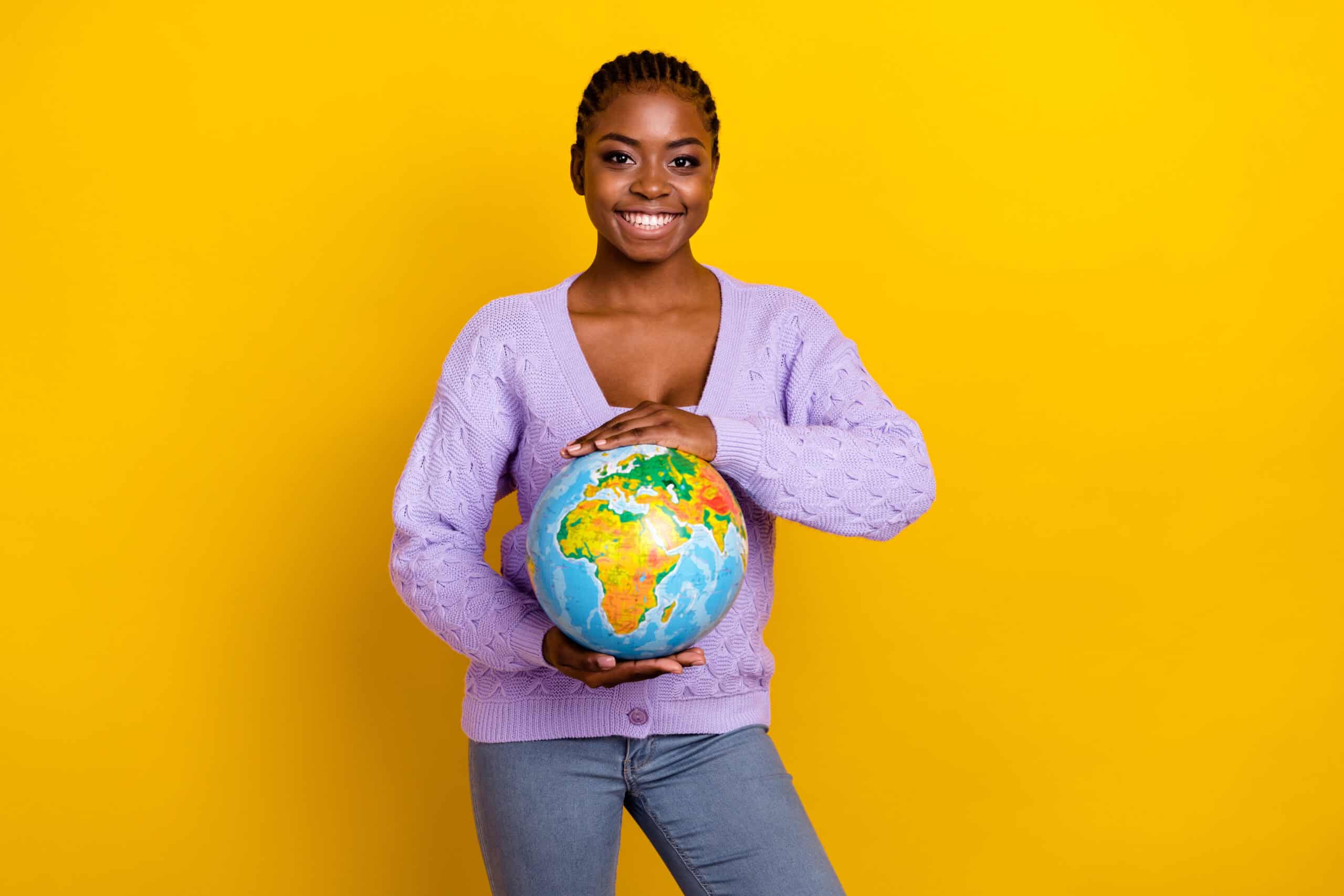 Photo of charming cheerful person arms hold planet earth globe toothy smile isolated on yellow color background.