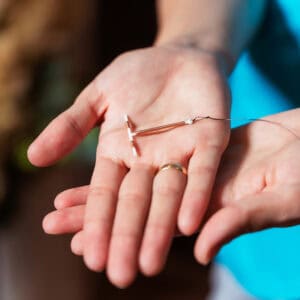 Female contraception copper IUD in the hands of a provider wearing a blue shirt